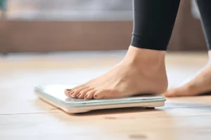 Close-up of a woman checking her weight, representing how tirzepatide works for weight loss