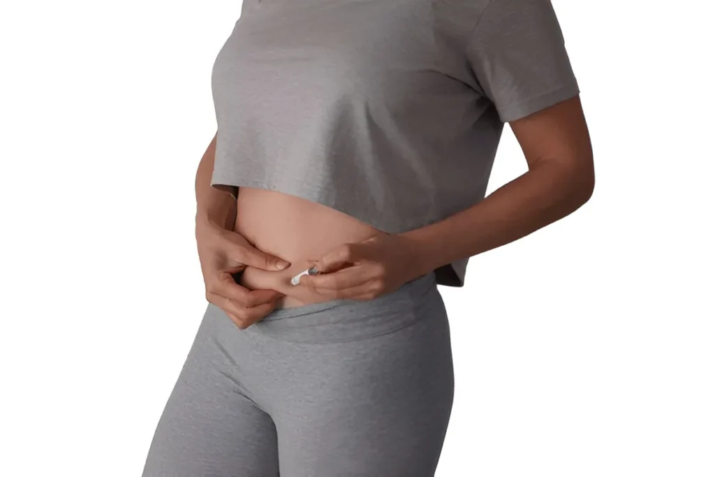 Woman self-injecting weight loss medication into her abdomen as part of a GLP-1 treatment routine.